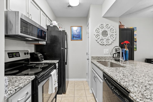 kitchen with light stone counters, stainless steel appliances, sink, and light tile patterned floors