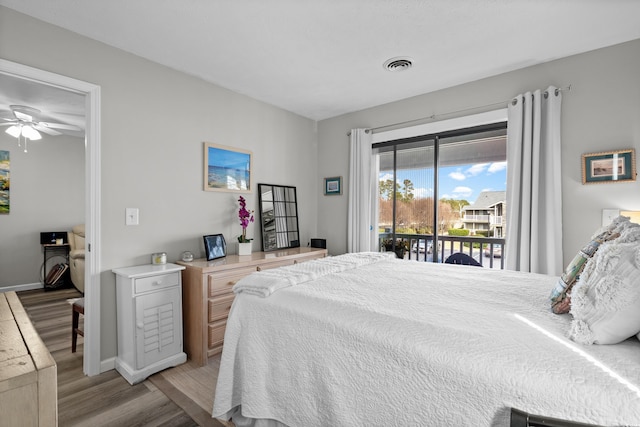 bedroom with access to exterior and light hardwood / wood-style flooring