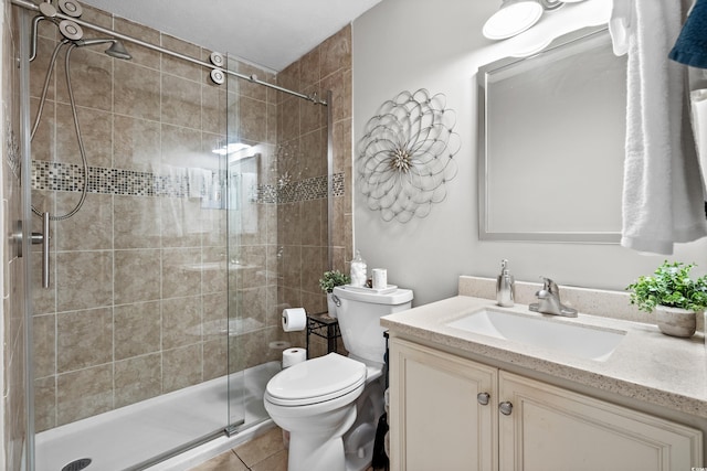 bathroom with tile patterned floors, vanity, toilet, and a shower with shower door