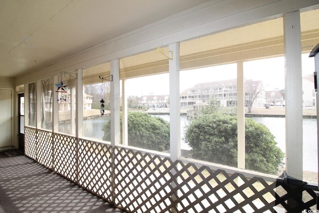 unfurnished sunroom featuring plenty of natural light and a water view