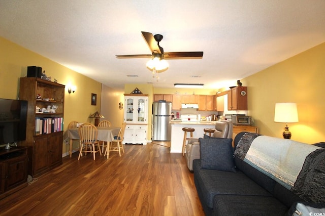 living room with ceiling fan and dark hardwood / wood-style floors