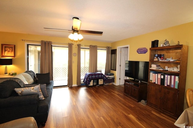 living room featuring dark hardwood / wood-style flooring and ceiling fan