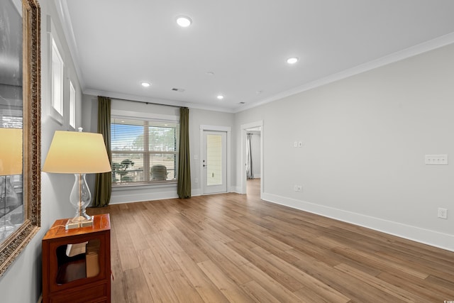 unfurnished living room with crown molding and light wood-type flooring