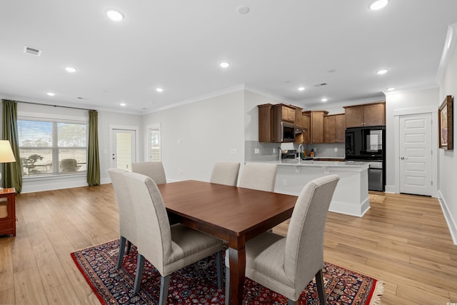 dining room featuring crown molding and light wood-type flooring