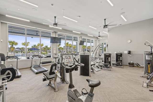 exercise room featuring light carpet, water heater, and ceiling fan