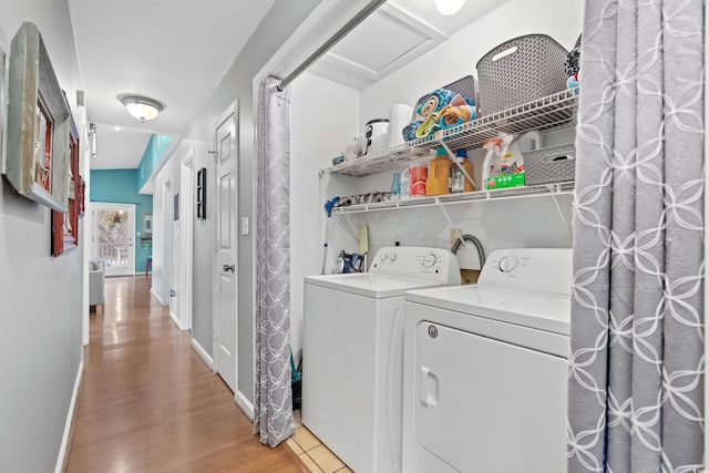 laundry area with laundry area, baseboards, independent washer and dryer, light wood finished floors, and attic access