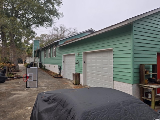 view of home's exterior with an attached garage and a chimney