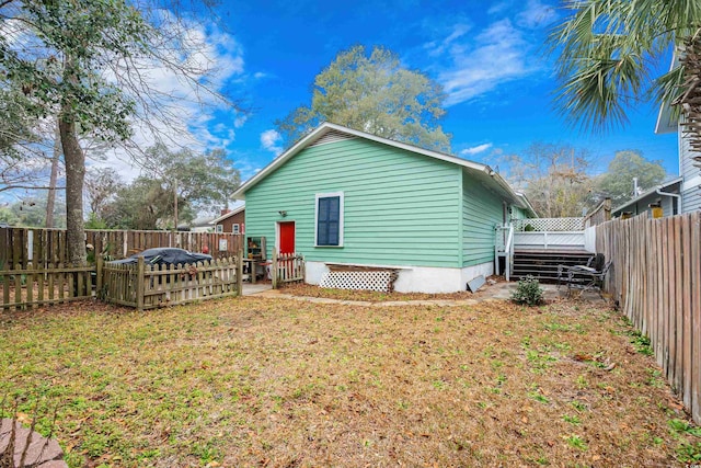 rear view of property with a deck, a yard, and a fenced backyard