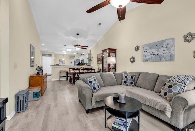 living room with vaulted ceiling, ornamental molding, light hardwood / wood-style floors, and ceiling fan