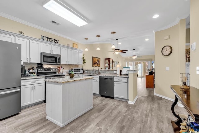 kitchen featuring pendant lighting, stainless steel appliances, light stone countertops, a kitchen island, and kitchen peninsula