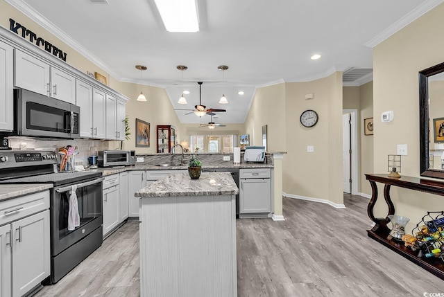 kitchen with pendant lighting, appliances with stainless steel finishes, ornamental molding, a kitchen island, and kitchen peninsula