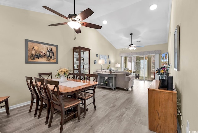 dining area with crown molding, light hardwood / wood-style floors, vaulted ceiling, and french doors