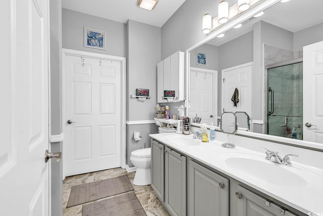 bathroom with a shower with door, vanity, and toilet