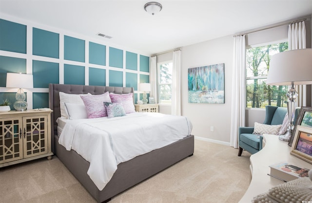 bedroom with multiple windows and light colored carpet