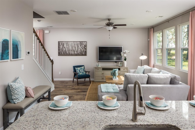 living room with dark wood-type flooring, ceiling fan, and sink