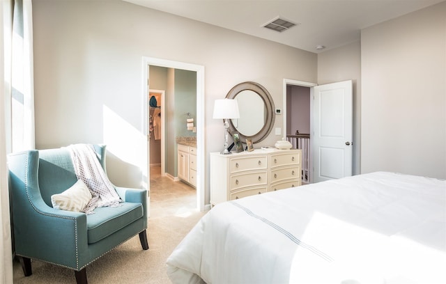 bedroom featuring light carpet, ensuite bath, and baseboards