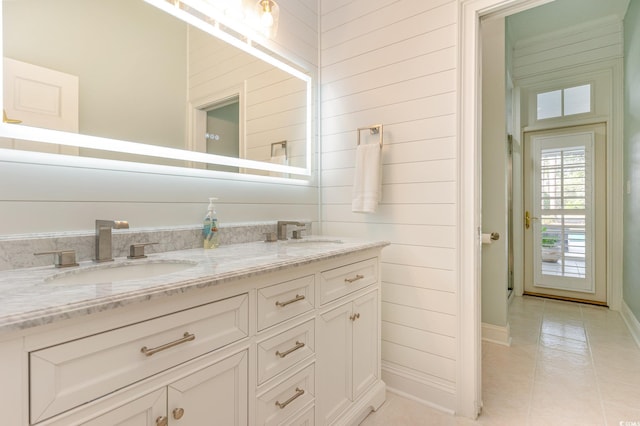 bathroom with vanity, tile patterned flooring, and wood walls