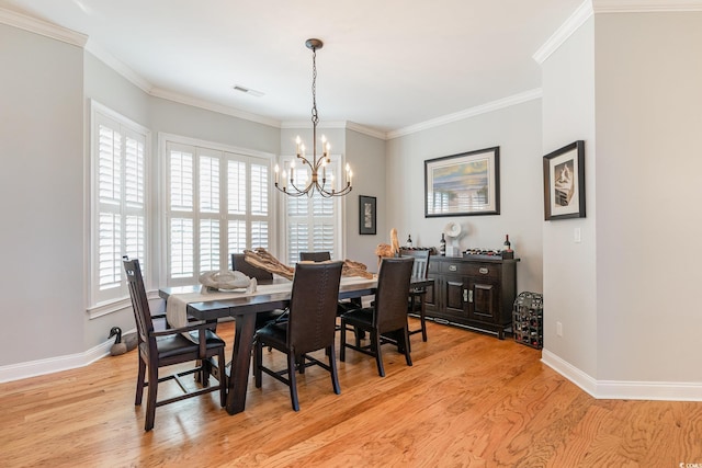 dining area with an inviting chandelier, ornamental molding, and light hardwood / wood-style flooring