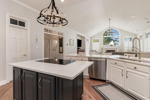 kitchen with sink, dishwasher, black electric stovetop, white cabinets, and a kitchen island