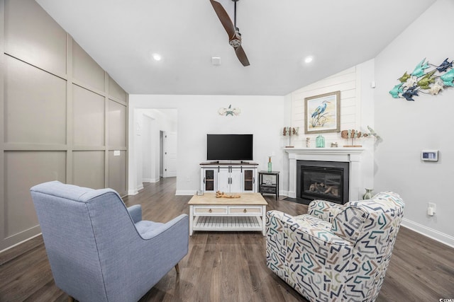 living room featuring ceiling fan, dark hardwood / wood-style flooring, and vaulted ceiling