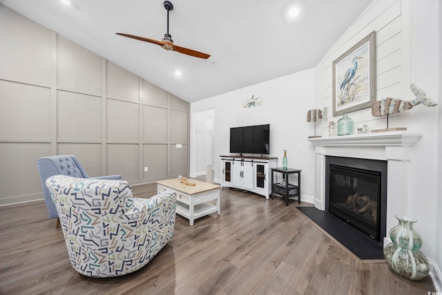 living room with vaulted ceiling, hardwood / wood-style floors, and ceiling fan