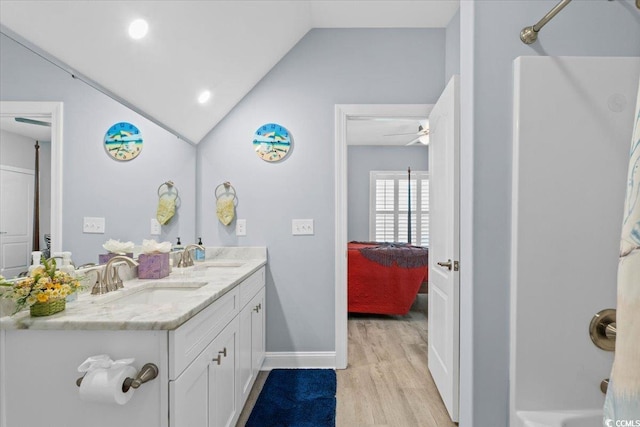 bathroom featuring lofted ceiling, vanity, hardwood / wood-style floors, and walk in shower