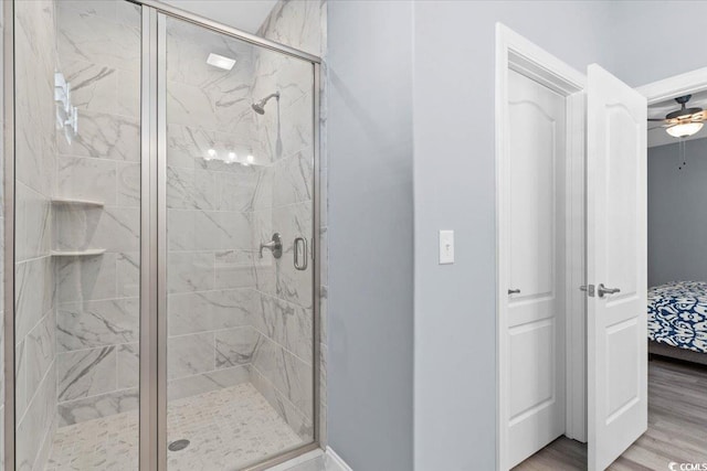 bathroom with hardwood / wood-style floors, an enclosed shower, and ceiling fan