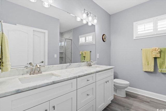 bathroom featuring vanity, toilet, a shower with door, and wood-type flooring