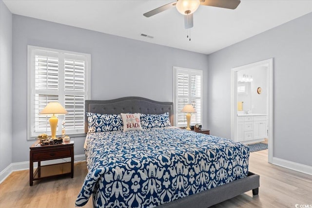 bedroom featuring ceiling fan, ensuite bathroom, and light wood-type flooring