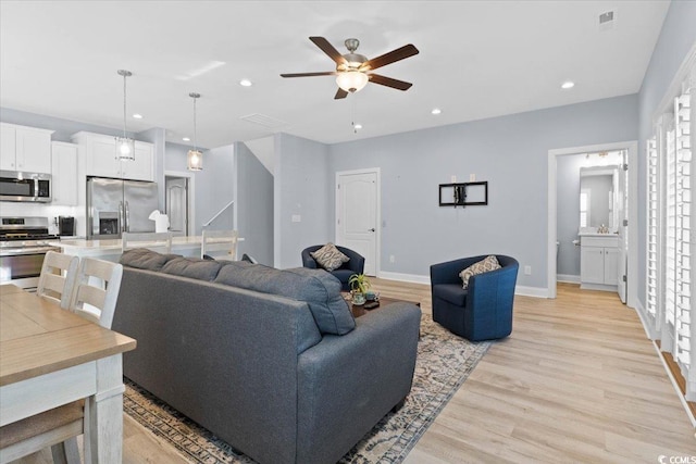 living room with ceiling fan and light hardwood / wood-style floors