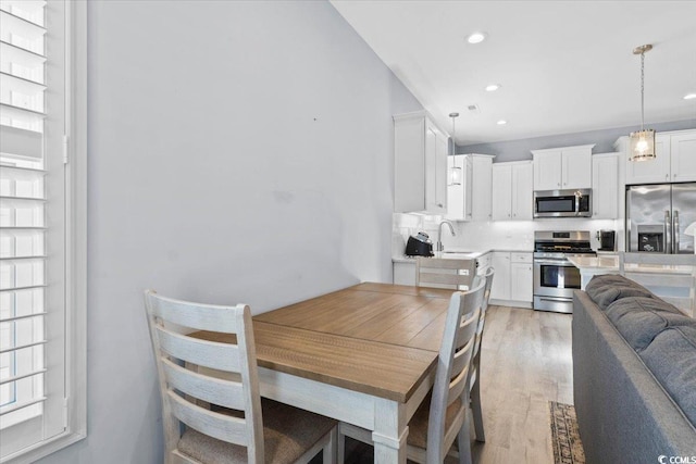 dining area with sink and light hardwood / wood-style floors