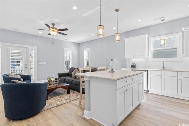 kitchen featuring sink, a breakfast bar, white cabinets, and a kitchen island