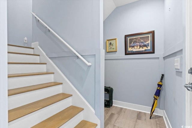 stairway with hardwood / wood-style flooring and vaulted ceiling