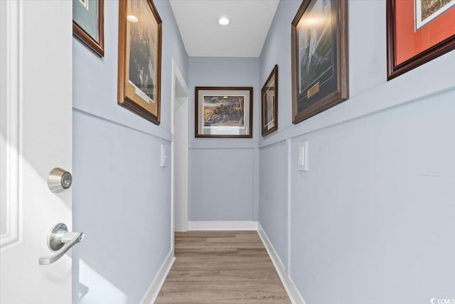 hallway with light hardwood / wood-style floors