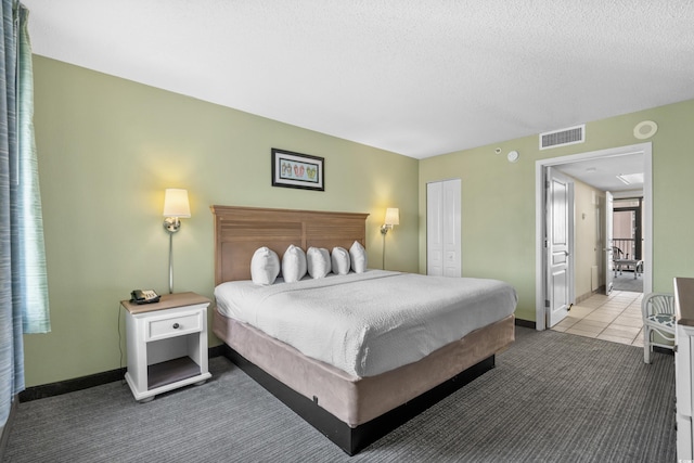 bedroom featuring carpet floors, a textured ceiling, and a closet