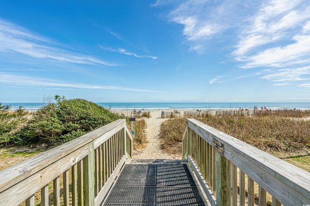 view of home's community featuring a water view and a beach view