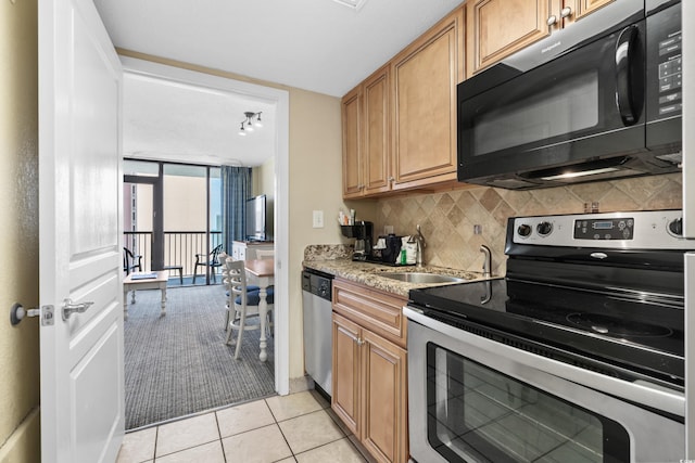 kitchen with sink, backsplash, light tile patterned floors, stainless steel appliances, and floor to ceiling windows