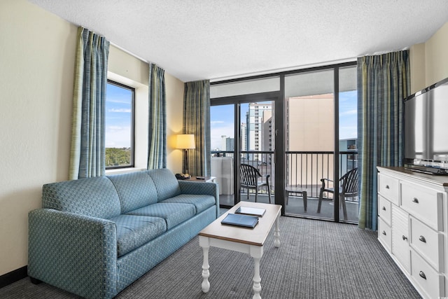 living room featuring dark carpet, floor to ceiling windows, and a textured ceiling