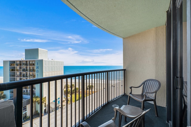 balcony with a water view and a beach view