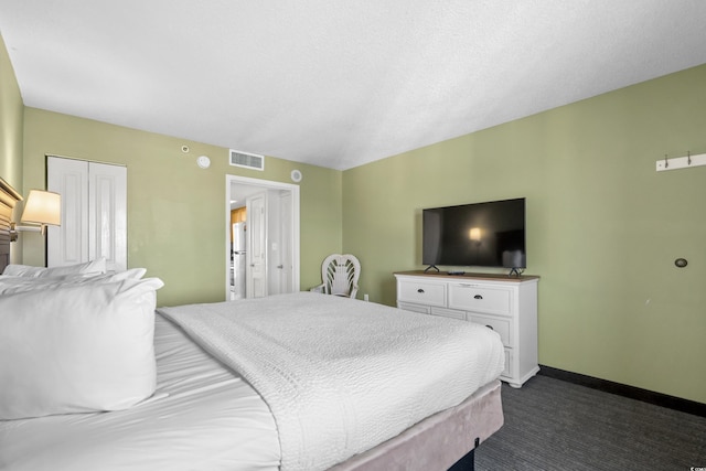 carpeted bedroom with a closet and a textured ceiling