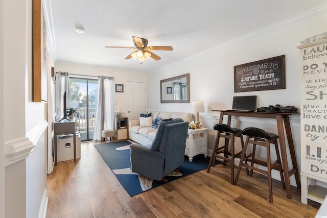 living room with ornamental molding, hardwood / wood-style floors, and ceiling fan