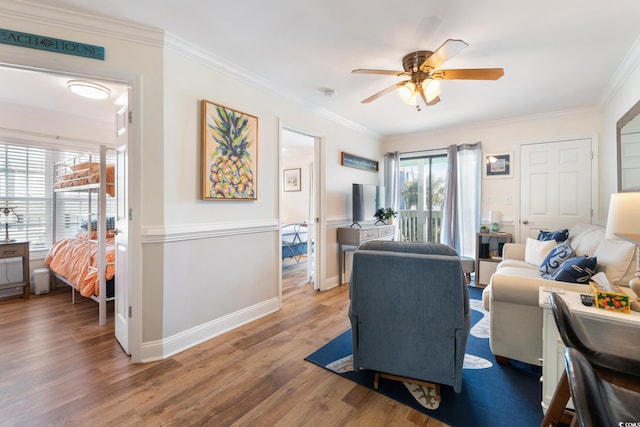 living room featuring crown molding, wood-type flooring, and ceiling fan