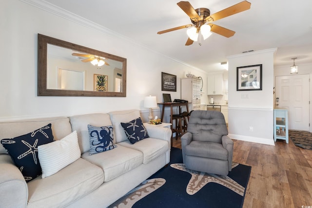 living room with hardwood / wood-style flooring, crown molding, and ceiling fan