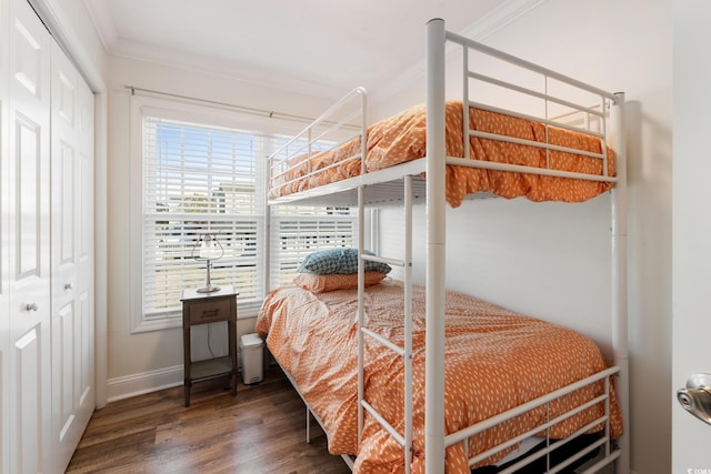 bedroom with crown molding, dark hardwood / wood-style floors, and a closet