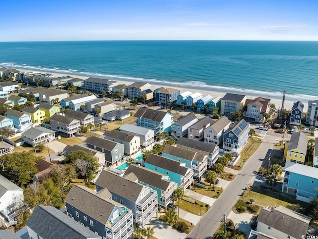 birds eye view of property with a water view and a beach view