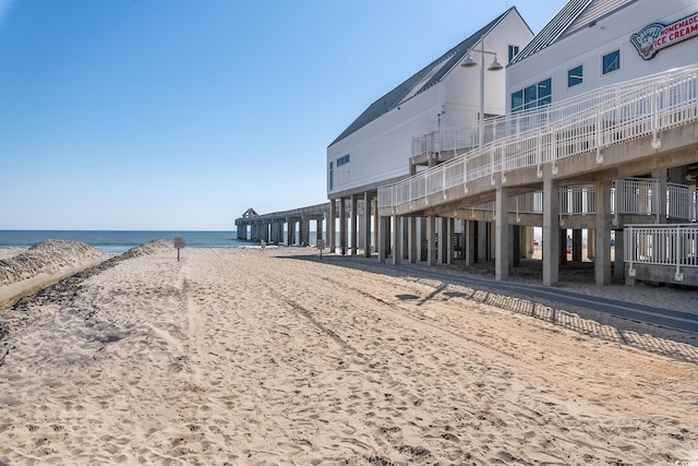 surrounding community featuring a water view and a beach view