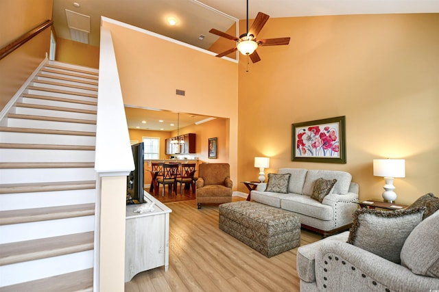 living room featuring high vaulted ceiling, light hardwood / wood-style floors, and ceiling fan