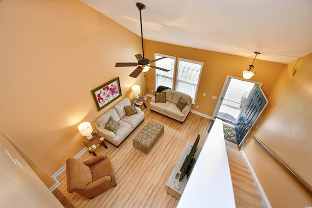 living room featuring lofted ceiling, hardwood / wood-style flooring, and ceiling fan