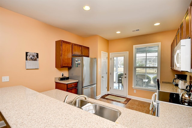 kitchen with sink, white appliances, and kitchen peninsula