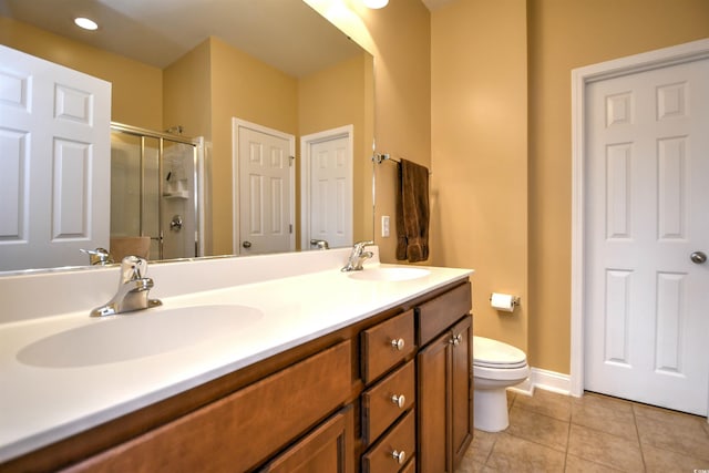 bathroom with tile patterned flooring, vanity, a shower with door, and toilet